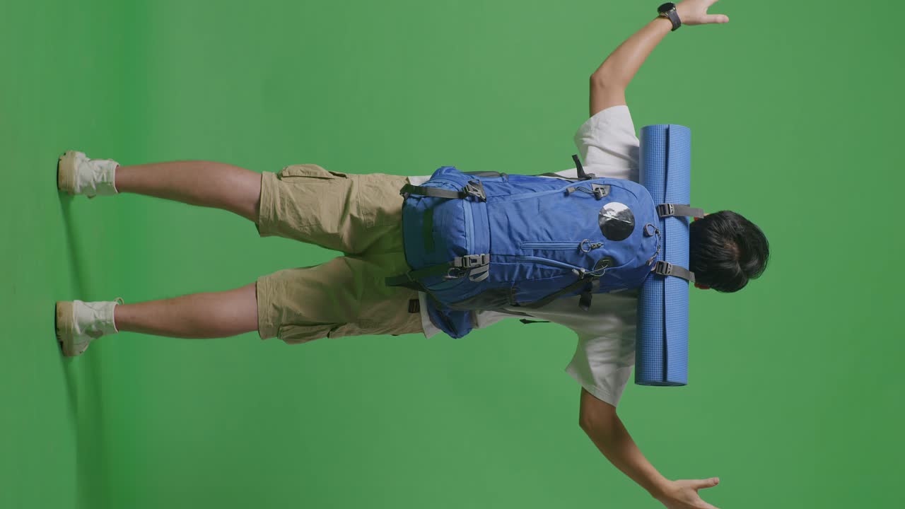 persona con mochila y estera de yoga en la pantalla verde