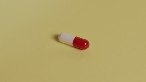 slow motion high-angle closeup of a pill as pills pour onto it