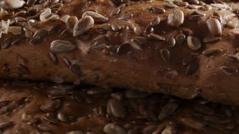 video of rotating bread with flax and sunflower seeds on black background