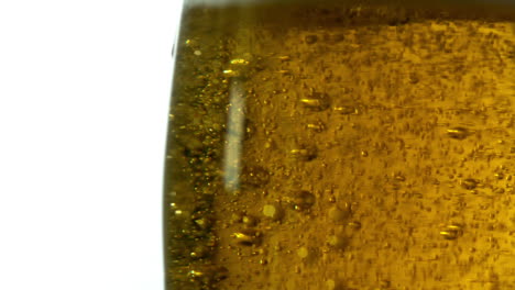 glass of beer bubbling on white background