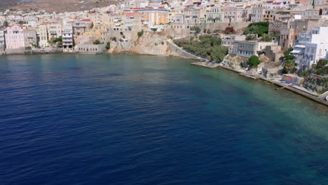 aerial: cámara panorámica lenta de la playa de asteria en ermoupoli de la isla de siros, grecia en un día soleado