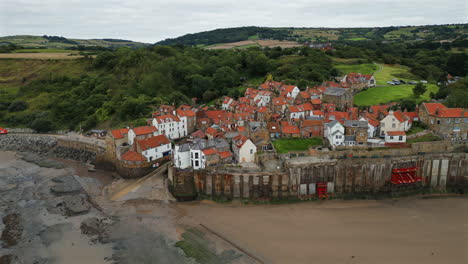 establishing aerial drone shot around robin hoods bay at low tide