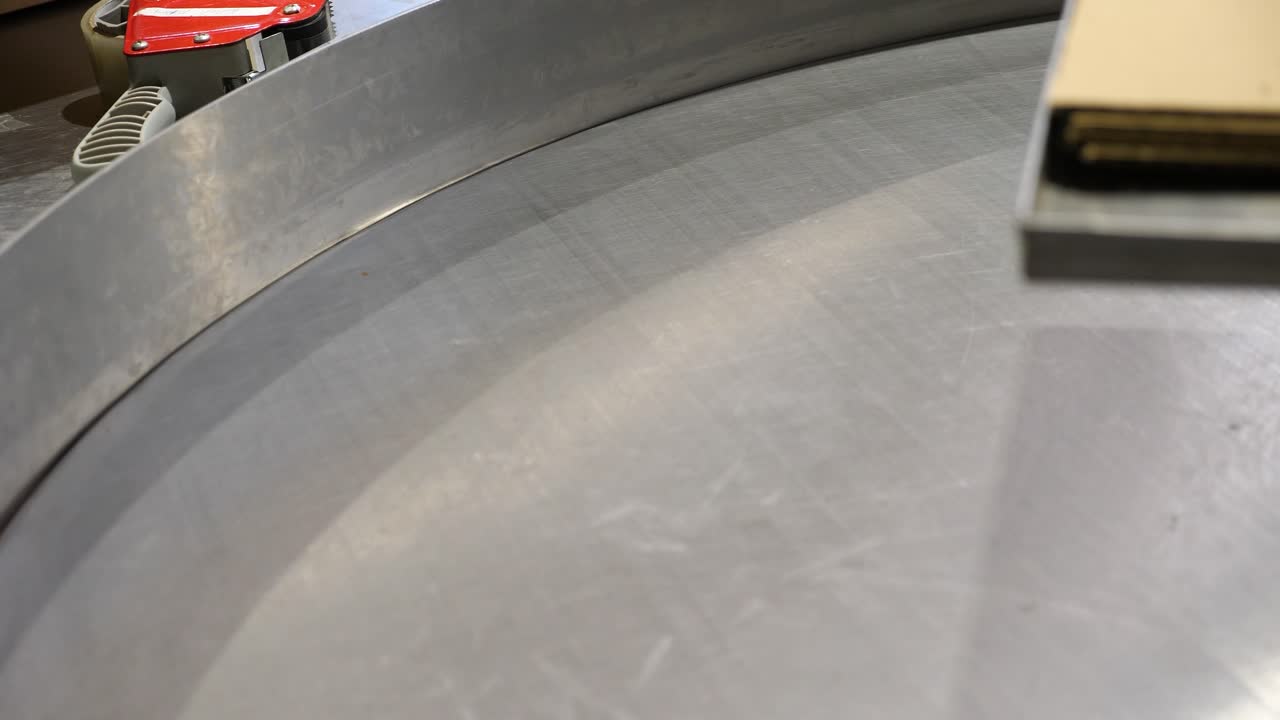 рабочий финиковой фабрики собирает с вращающегося конвейера завернутую упаковку фиников medjool на поднос