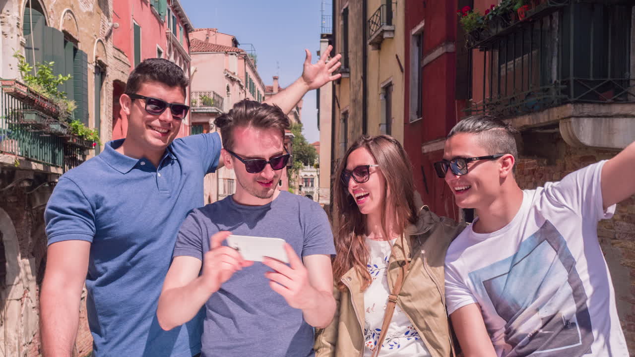Amigos tomándose una selfie en un canal de Venecia