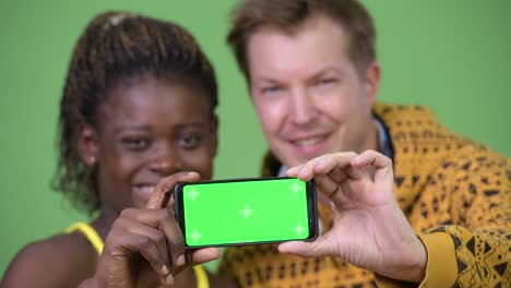 young multi-ethnic couple showing phone together