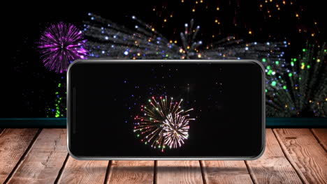 animation of fireworks exploding displayed on smartphone screen and on black background