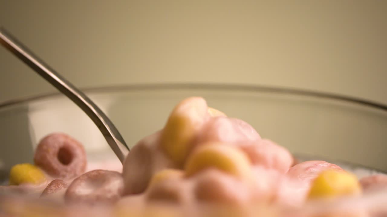 comiendo coloridos cereales de anillo con leche