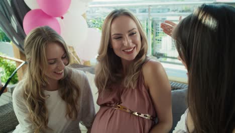 group of women talking by video call with absent  friend at baby shower.