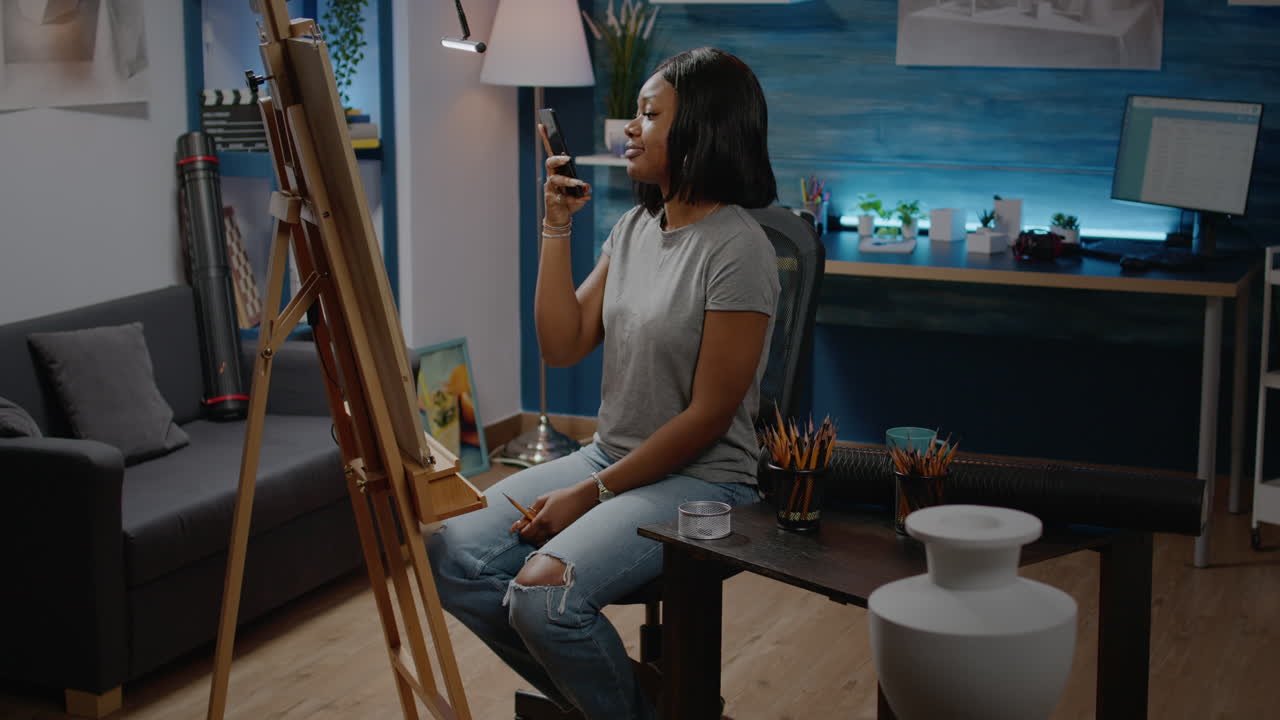 African american girl taking picture of drawing using smartphone