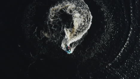 vista aérea superior de un joven montando una moto de agua en el mar en cámara lenta