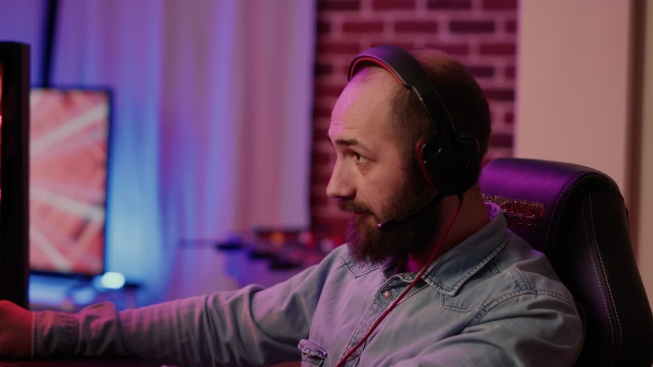 Closeup of man with gaming headset playing multiplayer online action game using professional pc setup