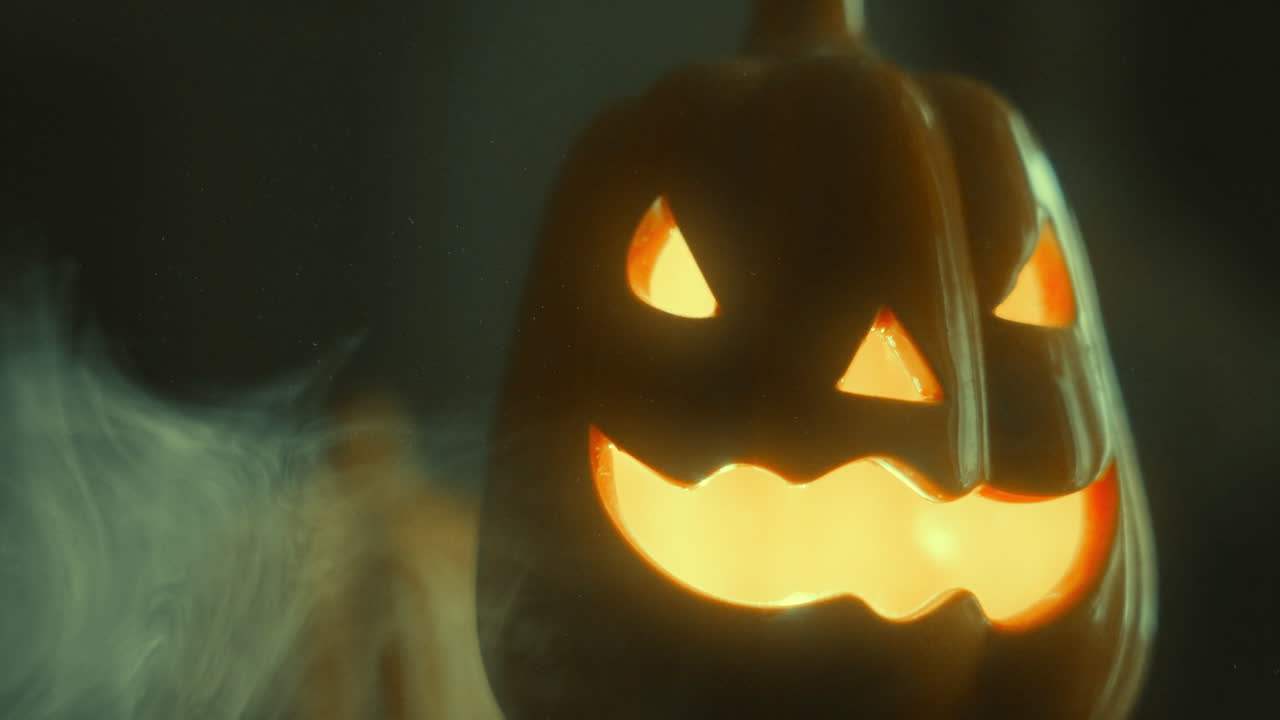 Primo piano di una zucca di Halloween luminosa con colori cangianti e fumo