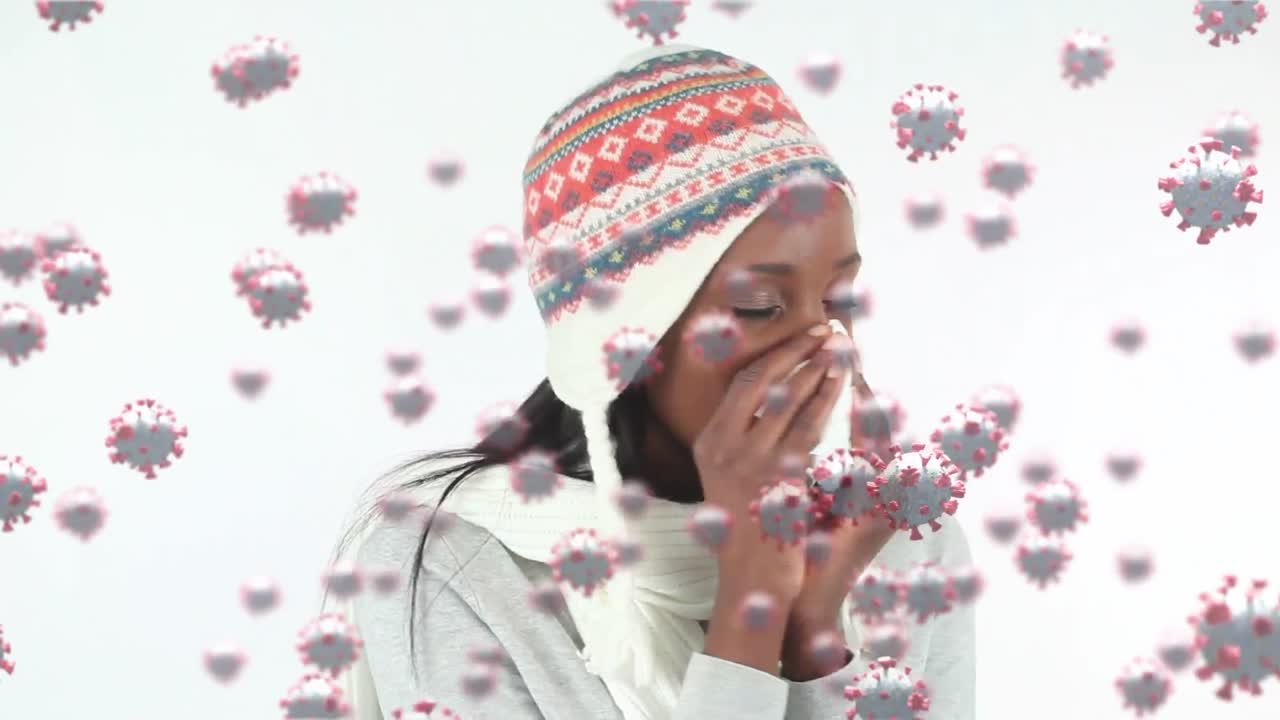 Animation of macro Covid-19 cells floating over mixed race woman sneezing