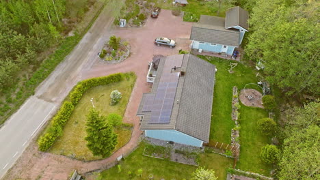 Drone-shot-overlooking-a-solar-powered-home-with-EV-car-charging-on-the-yard