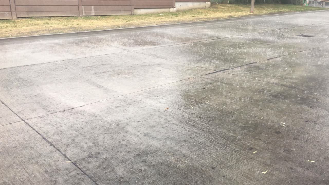 폭우와 홍수로 인해 시냇물이 도시 지역의 도로를 가로질러 흐릅니다.