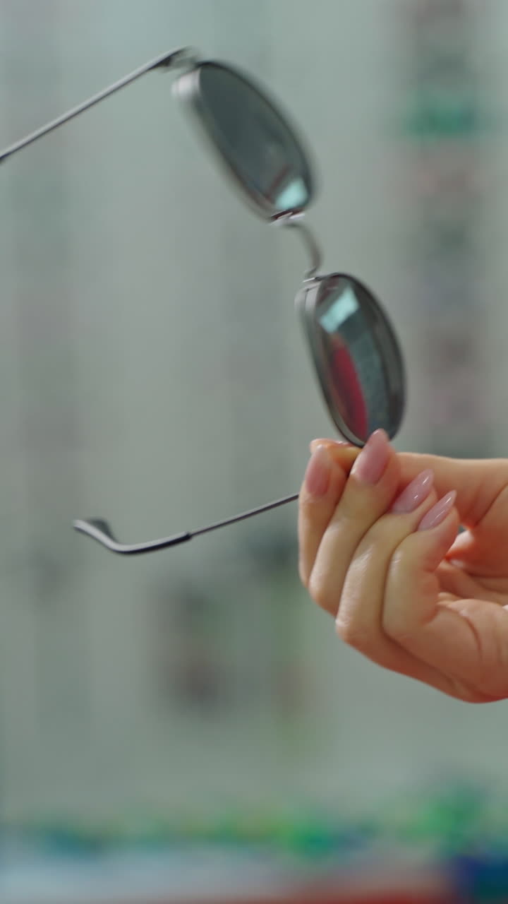 Woman at optician with glasses. Close up of woman hand holding sunglasses