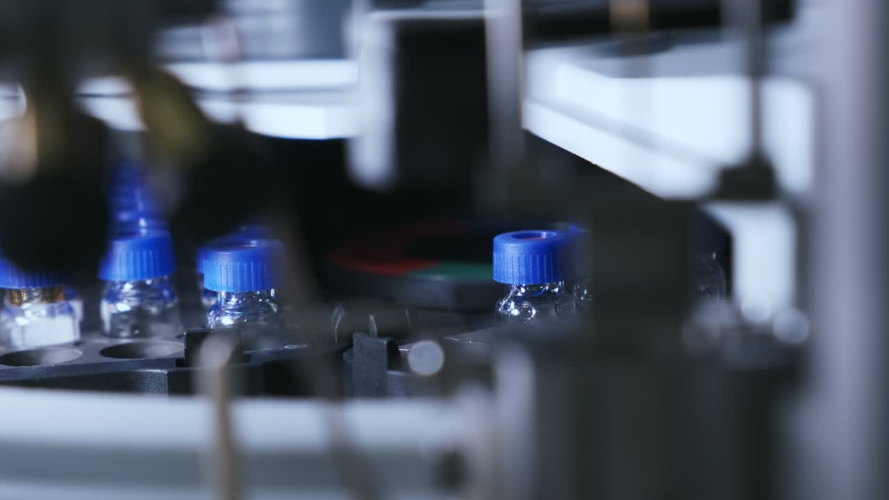 과학자는 실험실에서 hplc 자동 플러에 병을 넣습니다.