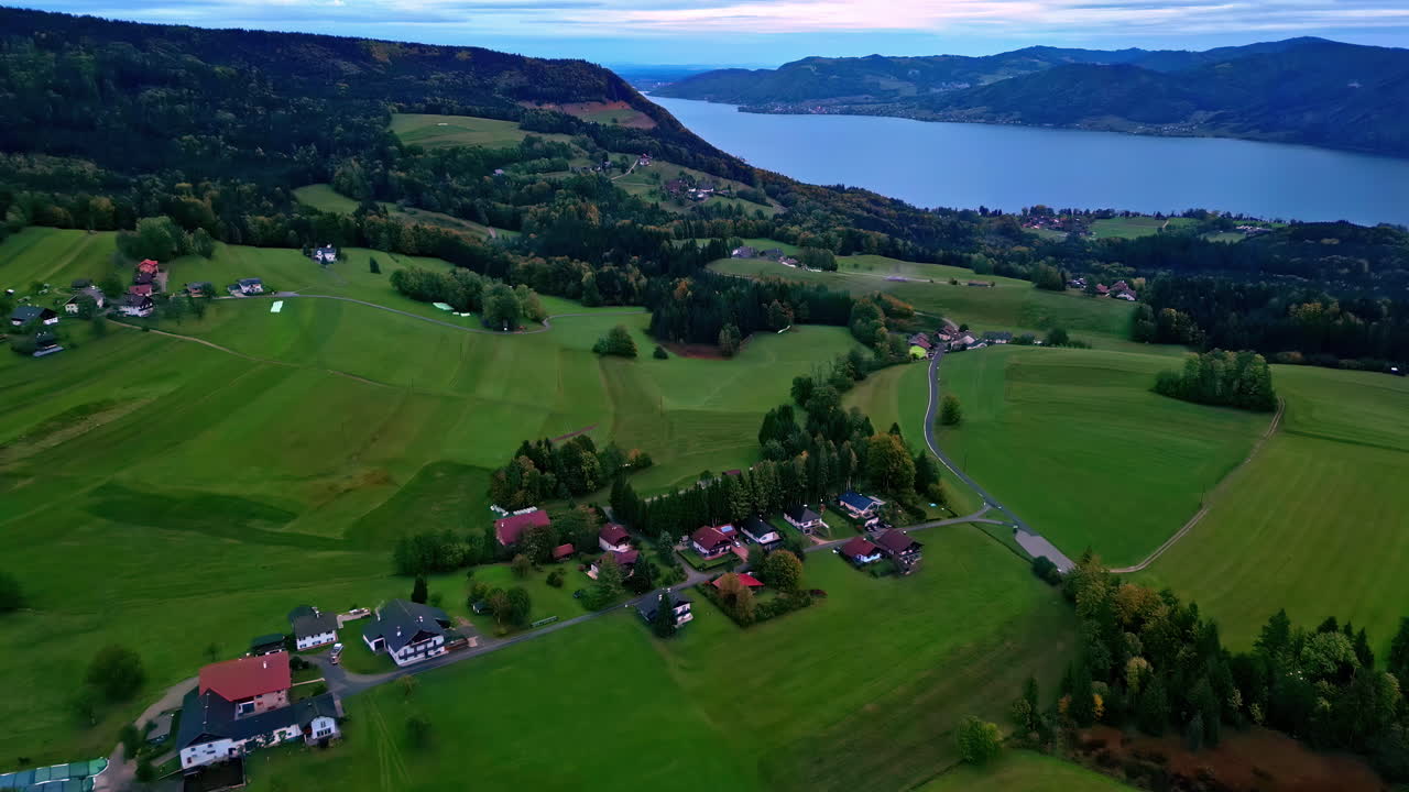 drone dolley tilt disparado sobre el valle verde en austria con el attersee en el fondo