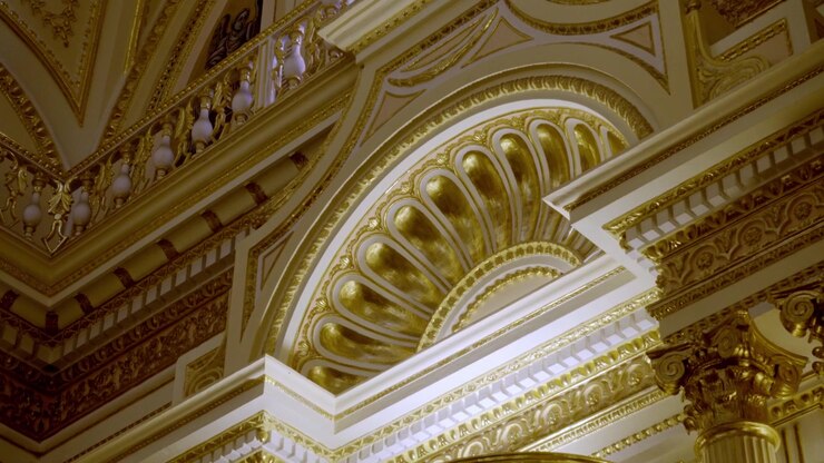Interno architettonico in oro decorato con un arco riccamente ornato, dettagli intagliati e colonne classiche. L'intricato ornamento dorato crea un elaborato ambiente storico in Messico