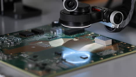 close-up of a circuit board undergoing optical inspection by a specialized device