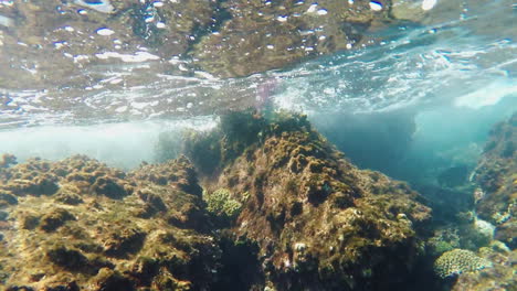 surf under water waves breaking on the rocks