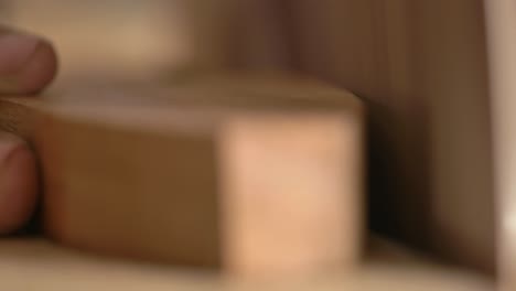 macro shot of a carpenter sanding wood on a industrial disc sander machine