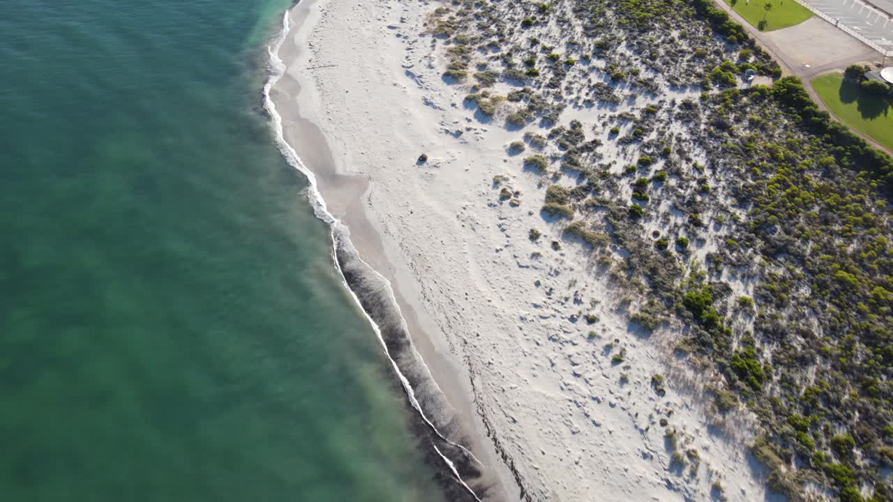 Drone aerial over pristine blue water and a white sand beach in Australia