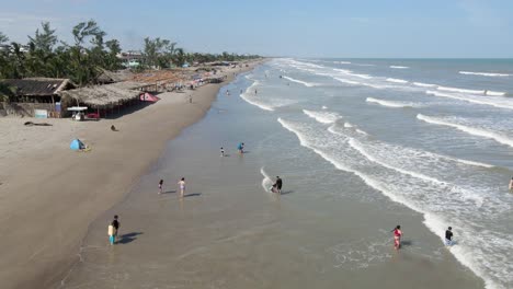 Unrecognizable-people-playing-and-having-fun-in-a-mexican-beach-at-Tecolutla,-drone-shot