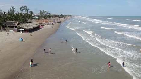 gente irreconocible jugando y divirtiéndose en una playa mexicana en tecolutla, tiro de drones