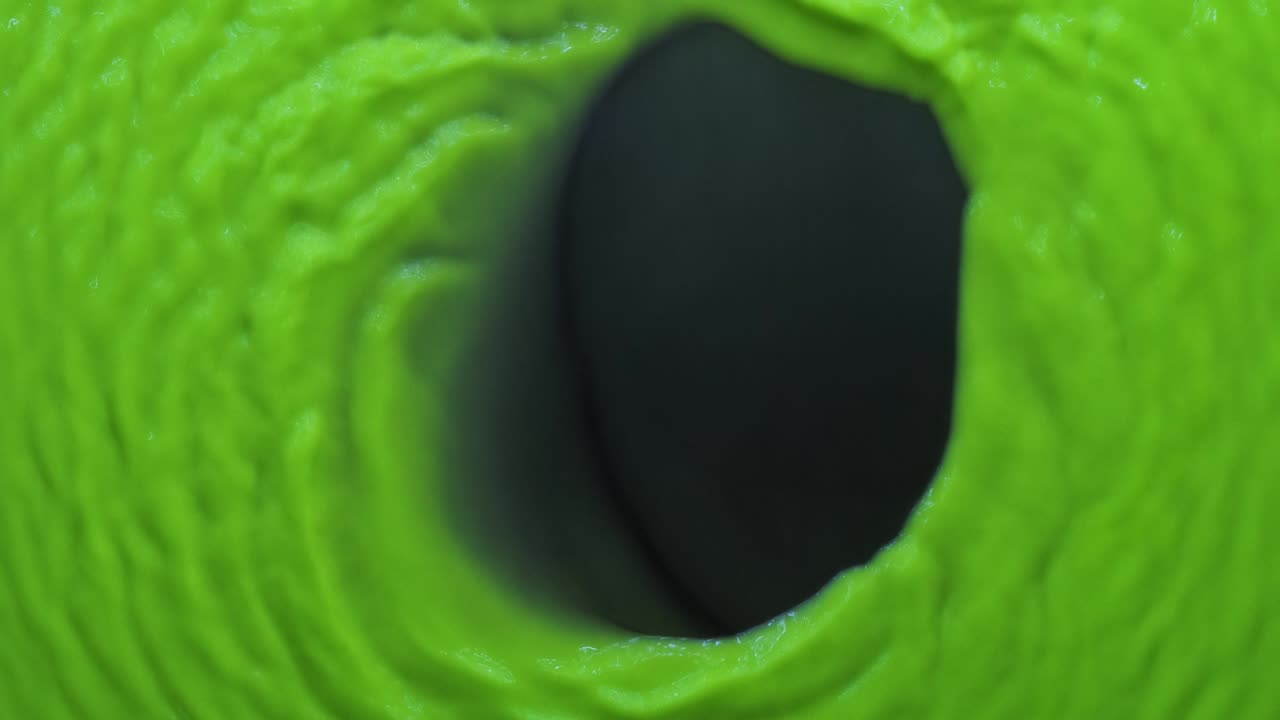 ondas abstractas de pintura de neón verde sobre un fondo azul. vista desde arriba.