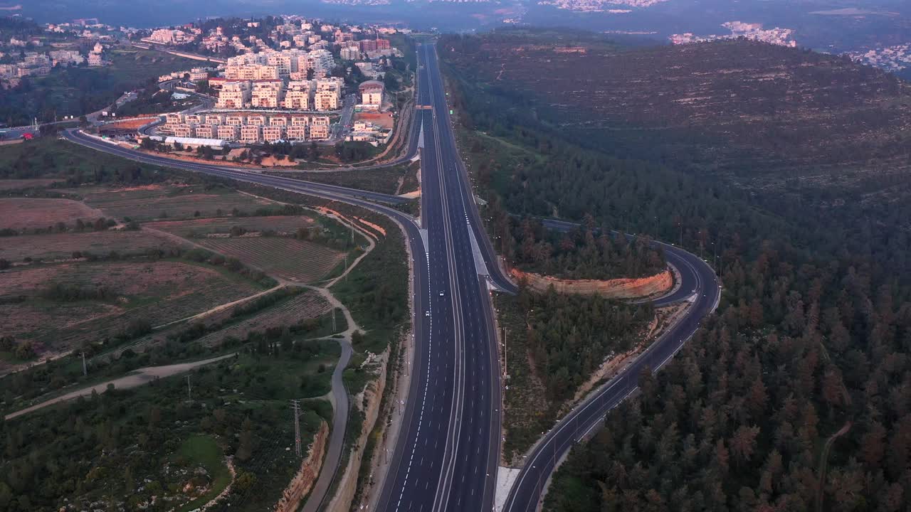 Aerial View of a Highway Interchange Near a Residential Town and Forest