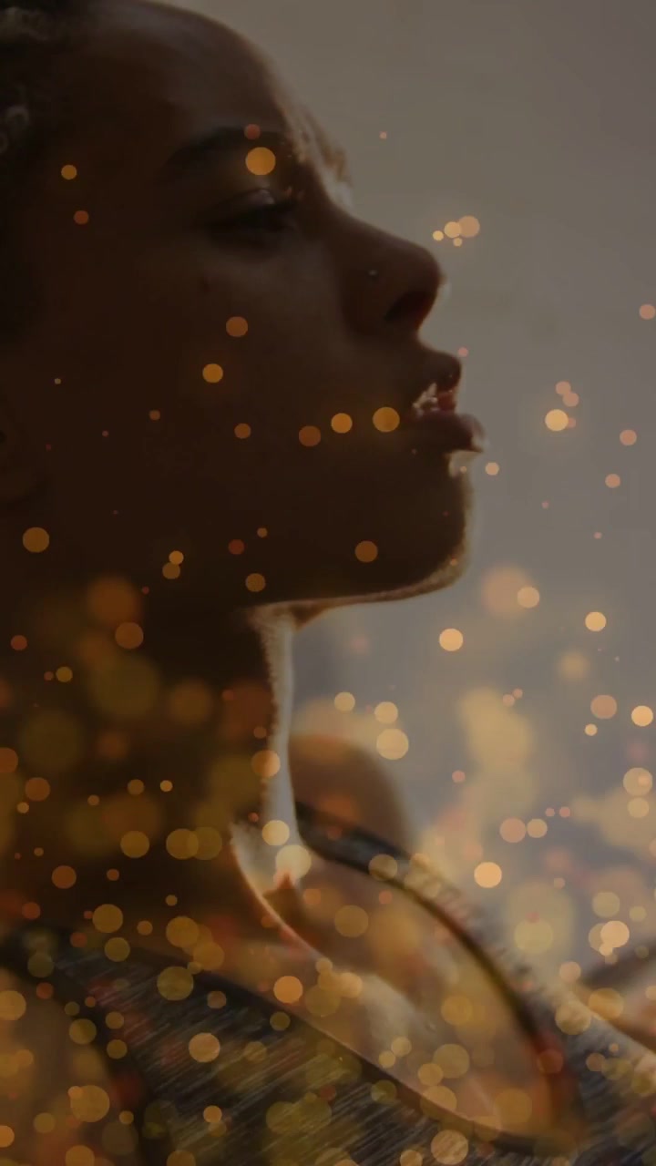 Video verticale: Donna in posa in studio, con bokeh dorato che fluttua e che lascia a bocca aperta per una pubblicità di bellezza.