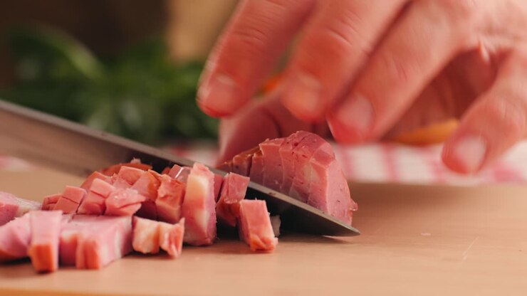 İtalyan mortadella jambonu, ahşap bir kesme tahtasında geleneksel İtalyan antipasti mortadella sosisi dilimleyen adam, tavuk veya hindi jambonunun yakın makro çekimi, yağlı kahvaltılık