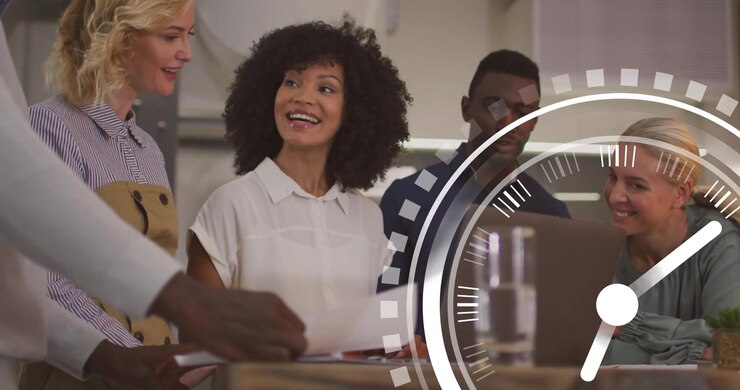 Business team reviewing docs on laptop while watching clock graphic rotating tracking project time