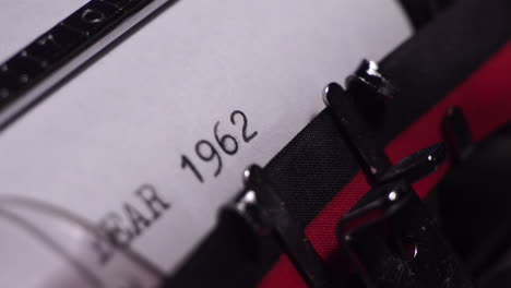 year 1962, typing on white paper in vintage typewriter, close up