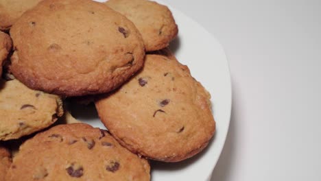 chocolate chip cookies on plate spin, copy space on white background, closeup