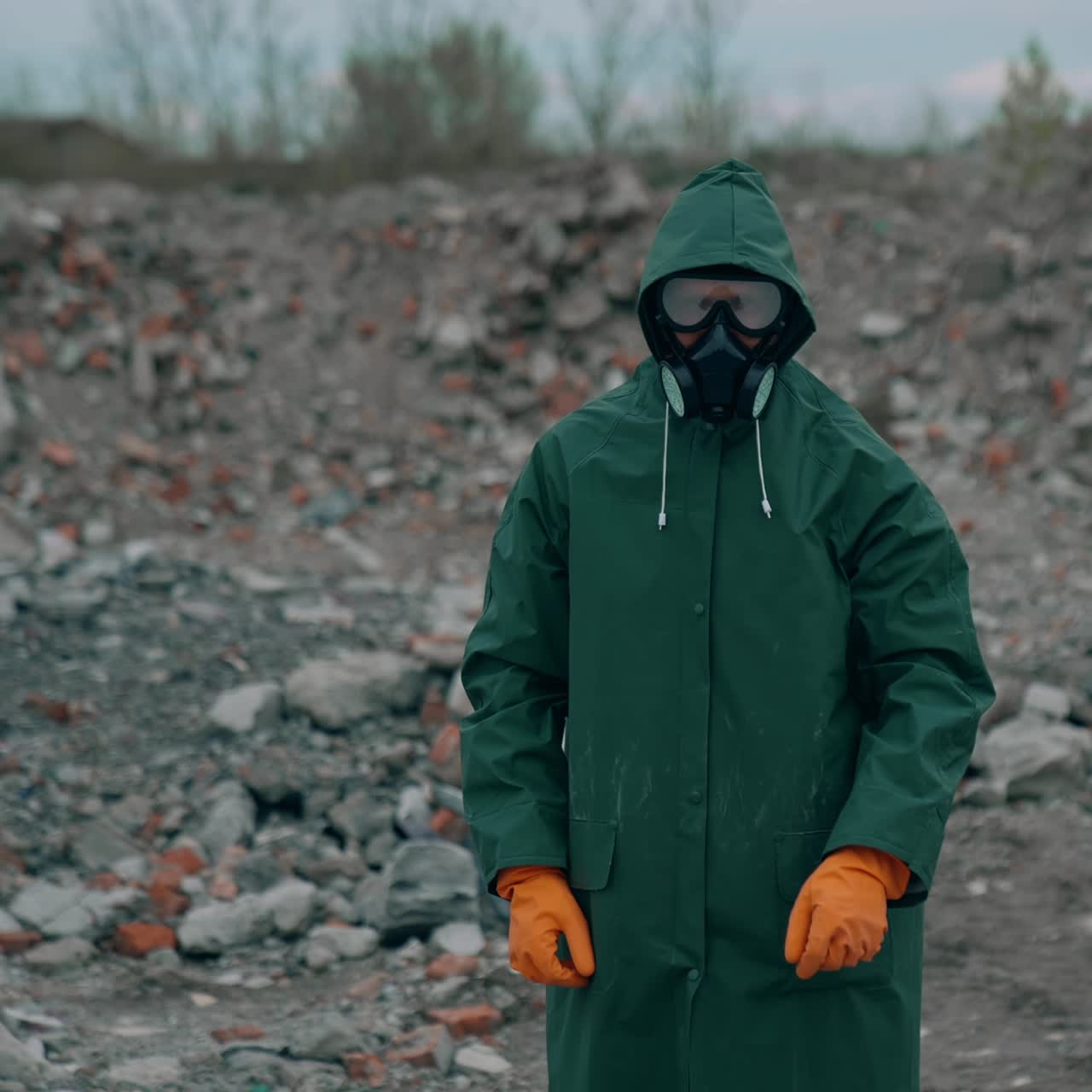 Portrait of a human in hazmat suit and respirator. Man in a protective suit and gas mask on the background of destroyed place
