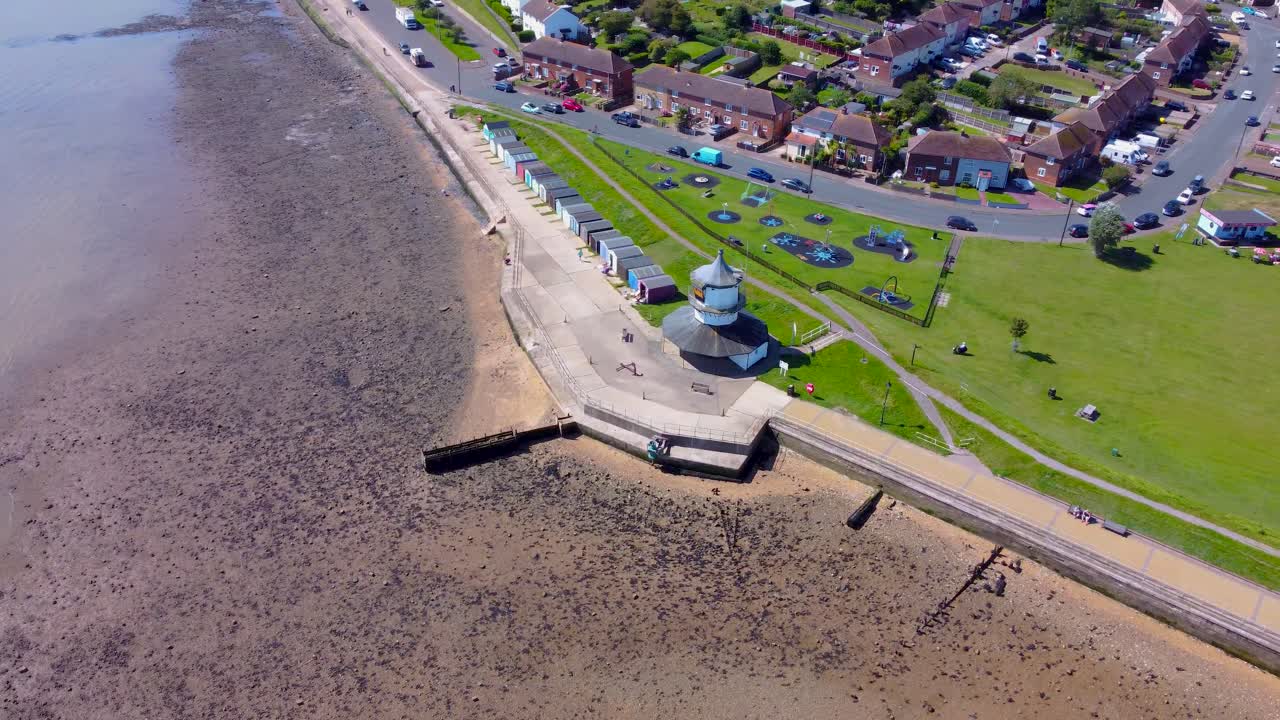 drone rotate around lighthouse in Harwich town in Essex, England, with traffic road and sunny seascape