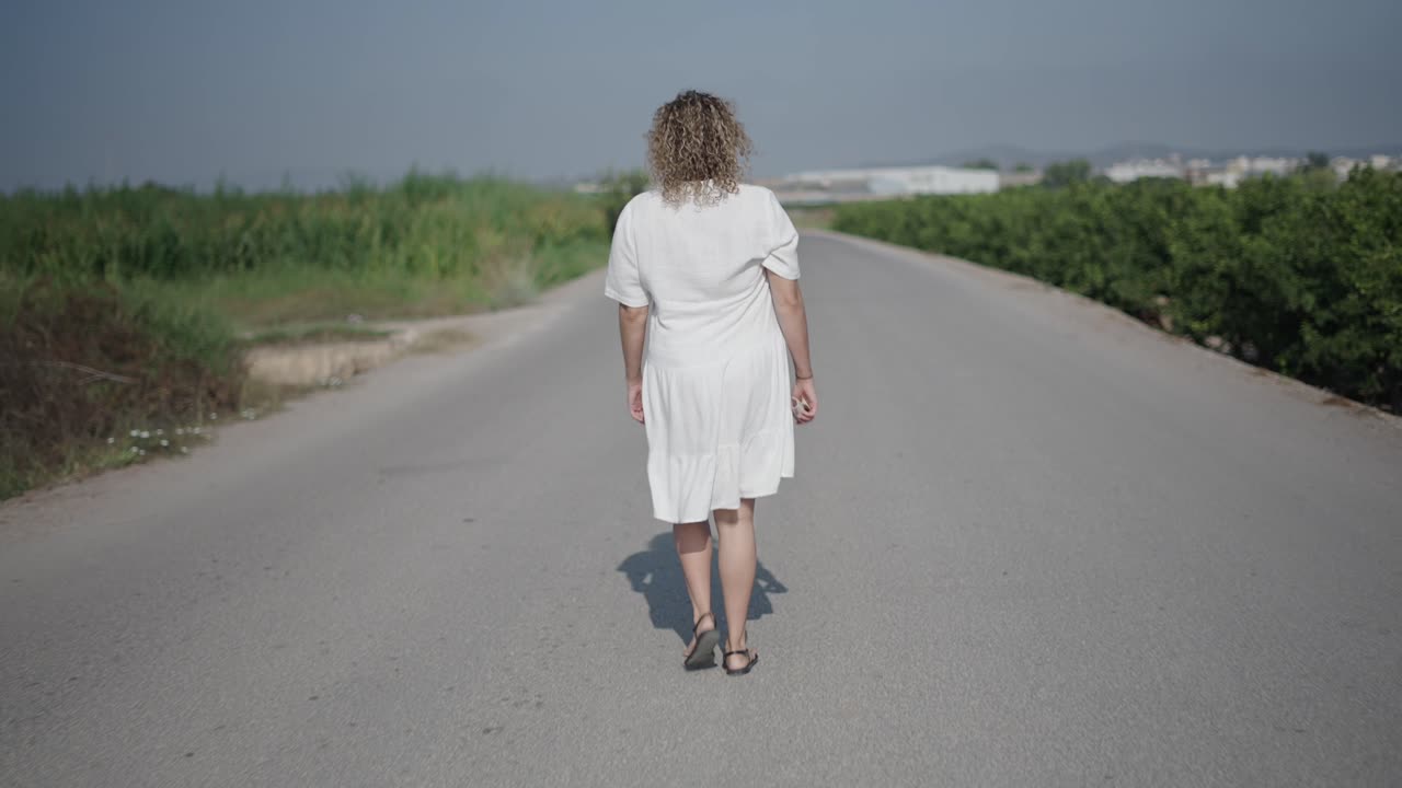 Woman Walking on a Country Road