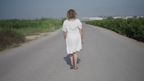 mujer caminando por un camino de campo