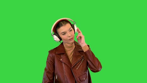 chica rocker escuchando música en auriculares en una pantalla verde, tecla de croma