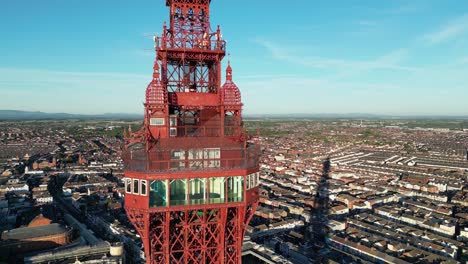 Luftdrohnenflug-Um-Die-Aussichtsplattform-Des-Blackpool-Tower,-Der-Die-Glasfenster-Und-Den-Boden-Zeigt-Und-Herumschwenkt,-Um-Die-Küste-Und-Die-Dächer-Darunter-Zu-Zeigen