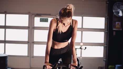 Determined-Young-Woman-Cycling-On-Stationary-Bike-At-Fitness-Studio-7