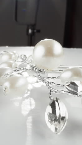 elegant white pearls and faceted clear crystals necklace on a reflective surface