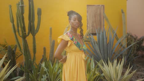 woman in yellow dress amongst cactus and plants