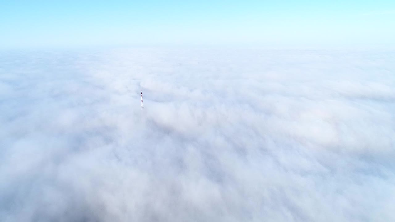 vuelo sobre nubes brumosas a la luz del sol de la mañana con poca gloria y paisaje urbano bajo las nubes