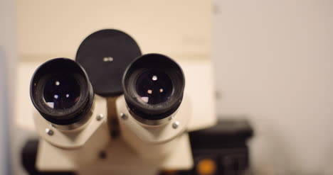 close up panning shot of binocular optical microscope in laboratory