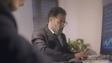 Two-businessmen-working-together-in-office-late