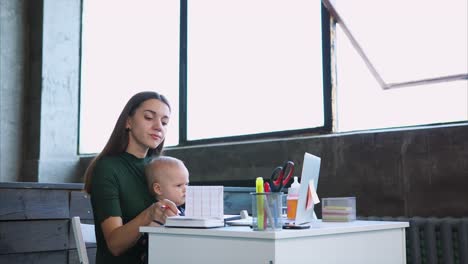 madre trabajando con el bebé en casa