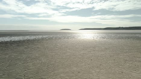 Volando-En-La-Orilla-Arenosa-De-La-Playa-De-Pilmore-Strand-Durante-La-Marea-Baja-En-El-Condado-De-Cork,-Irlanda